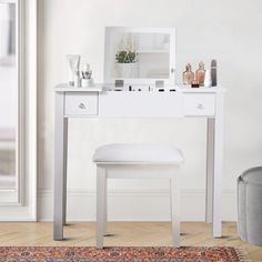 a white vanity table with a mirror and stool in front of it on a rug