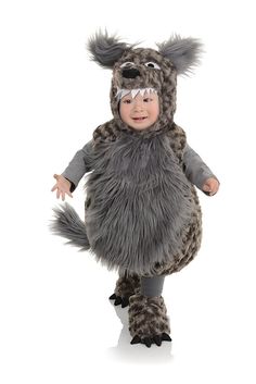 a baby dressed up in a furry animal costume, standing on one leg and looking at the camera