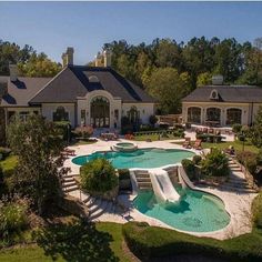 an aerial view of a house with a pool and slide in the front yard, surrounded by greenery