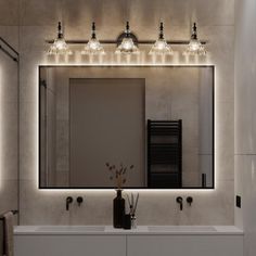 a bathroom with a sink, mirror and lights on the wall above it's sinks