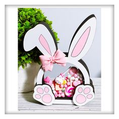 a bunny shaped box filled with candy next to a potted plant