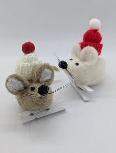 two needled mice with knitted hats on their heads and needles in front of them