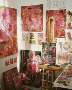 an artist's studio with many paintings on the wall