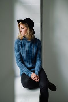 a woman in a blue sweater and black hat