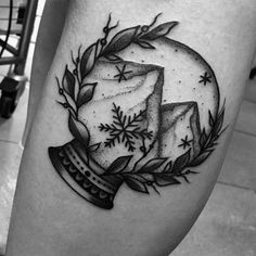 a black and white photo of a snow globe tattoo