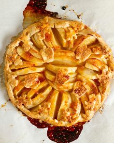 an apple pie is sitting on top of wax paper with crumbled toppings