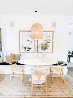 a dining room table with chairs and a bench in front of the wall that has pictures on it