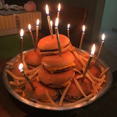 hamburgers with candles are stacked on top of each other in order to be eaten