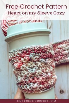 a hand holding a coffee cup with crochet on it and text overlay that says, free crochet pattern heart on my sleeve cozy