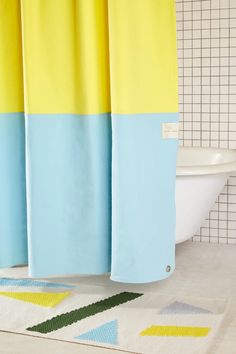 a bathroom with yellow and blue shower curtains