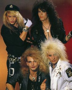 three women in black outfits posing for a photo with one holding her hand up to the side