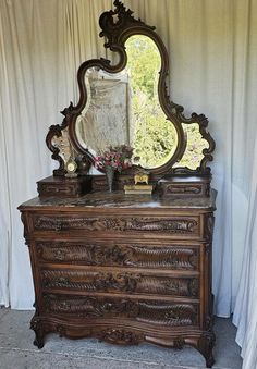 an antique dresser with a mirror on top