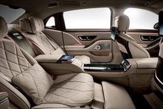 the interior of a luxury car with beige leather and black trims, including an entertainment center