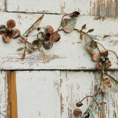 an old white painted door with flowers on the outside and rusted metal parts attached to it