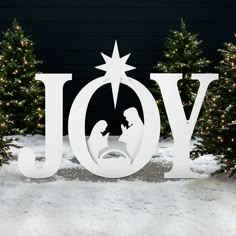 the word joy is displayed in front of christmas trees with lit up lights and a nativity scene