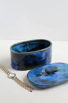 two blue bowls and a chain on a white surface