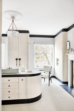 a large kitchen with white cabinets and black trim on the countertop, along with a fireplace