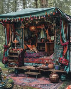 a bed in the middle of a forest with lots of decorations on top of it