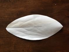 a piece of paper that is on top of a wooden table and has been folded in half