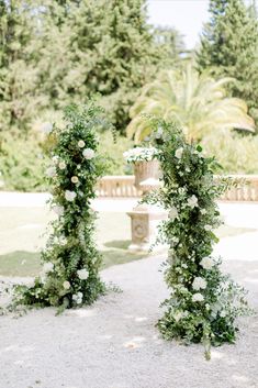 an outdoor ceremony setup with white flowers and greenery