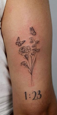 a woman's arm with flowers and butterflies tattoo on the left side of her body