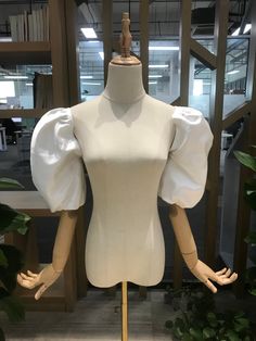 a mannequin wearing a white dress with puffy sleeves