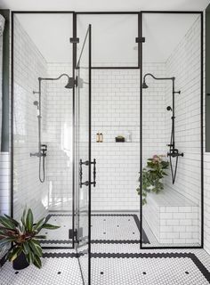 an image of a bathroom with black and white tile on the walls, shower head, and sink