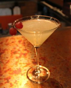 the martini is ready to be served with cherries on the rim and garnish