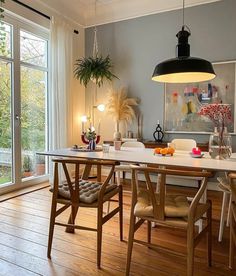 a dining room table and chairs in front of a large window