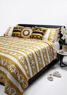 there is a bed with yellow and white bedspread on the floor next to shoes