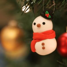 a snowman ornament hanging from a christmas tree