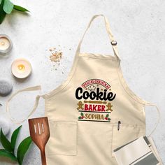 an apron with the words cookie maker on it next to some candles and other items