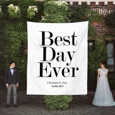 a man and woman standing next to a white banner that says best day ever on it