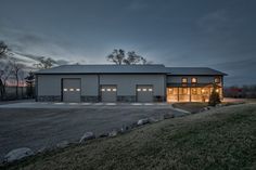 a large house with two garages and lights on