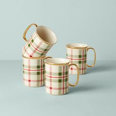 three plaid mugs stacked on top of each other in front of a blue background