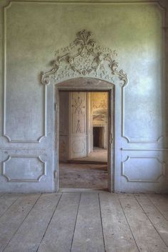 an open door leading into a room with white walls and wood flooring on either side