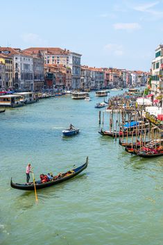 two boats in the water with people on them and buildings lining the sides of the water