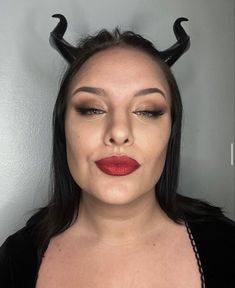 a woman with horns on her head and red lipstick