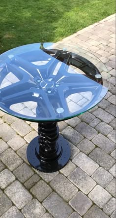 a glass table sitting on top of a brick walkway