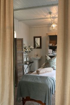 a bed sitting under a window next to a bathroom