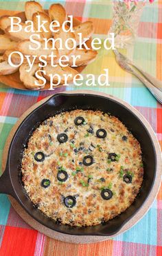 baked smoked oyster bread in a cast iron skillet with olives on the side