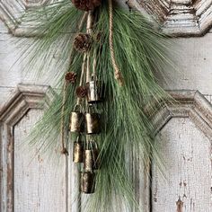 an old door decorated with pine cones and bells