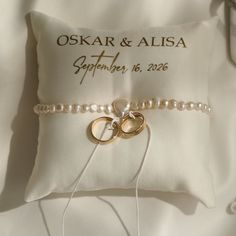 a wedding ring pillow with two rings on it and a couple's name written on the pillow