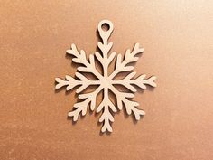 a wooden snowflake ornament sitting on top of a brown tablecloth