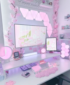 a desk with two computer monitors, keyboard and mouse in front of pink flowers on the wall