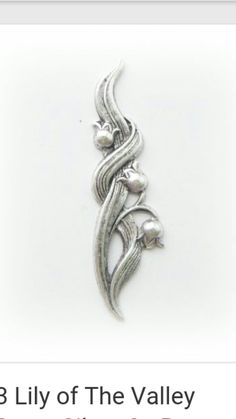 a silver brooch with pearls on it