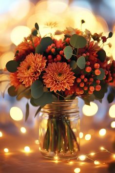 an arrangement of flowers in a mason jar on a table with string lights behind it