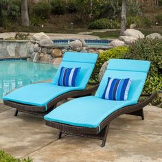 two chaise lounge chairs next to a swimming pool