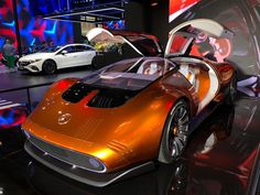 an orange sports car on display in a showroom