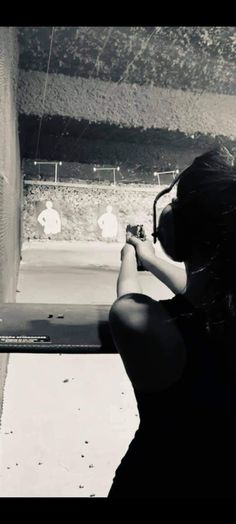 a woman taking a photo with her cell phone while standing in front of a window